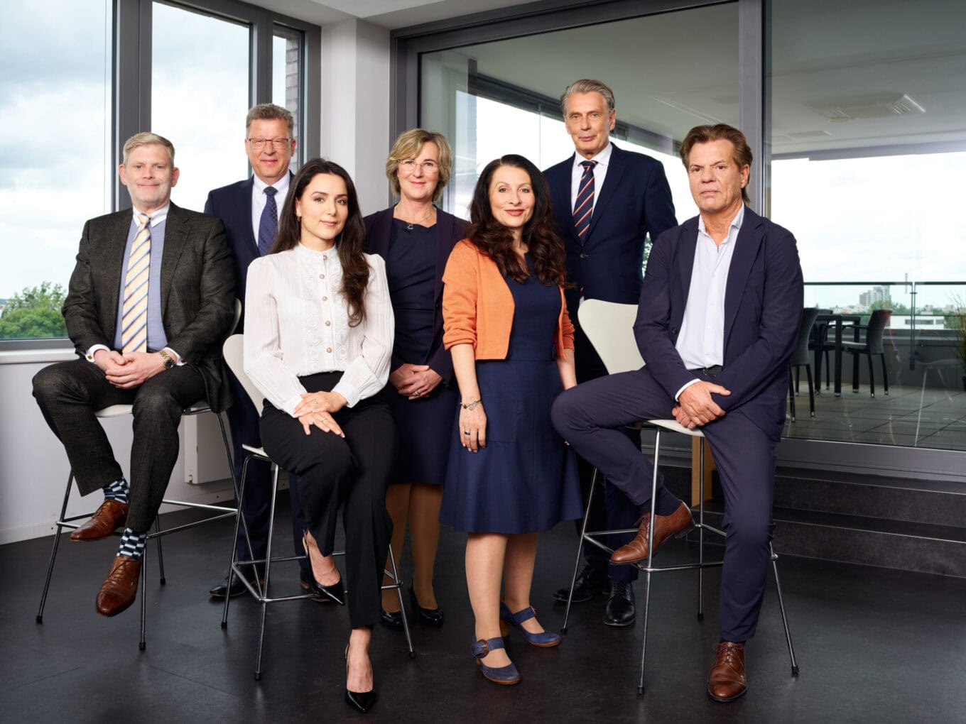 Kierownictwo firmy ZAG w nowoczesnym biurze z dużymi oknami i widokiem na miasto, profesjonalne zdjęcia zespołu.