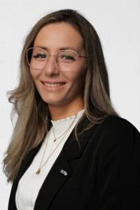 Retrato de una joven con gafas, de aspecto profesional y amable.